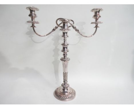A Sheffield plated two branch, three light Candlestick with floral and leafage decorated tapering column on gadroon circular 