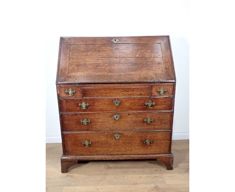 A George III oak Bureau with fielded fall front enclosing pigeon holes and drawers above two short and three long graduated d