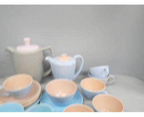 A Poole pottery part tea service, two tone comprising of teapot, seven cups, (five peach and two blue), saucers, milk jug, su