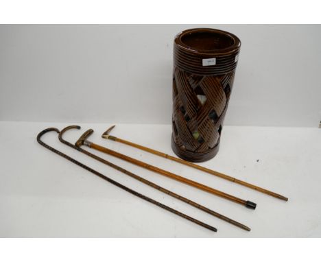 A treacle woven design glaze stick stand, together with four walking sticks, two with silver collars  **NOT ELIGIBLE FOR IN H