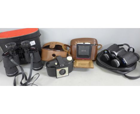 A collection of cameras and binoculars including a Kodak Brownie 127 with case and a Zeiss Ikon Nettar 