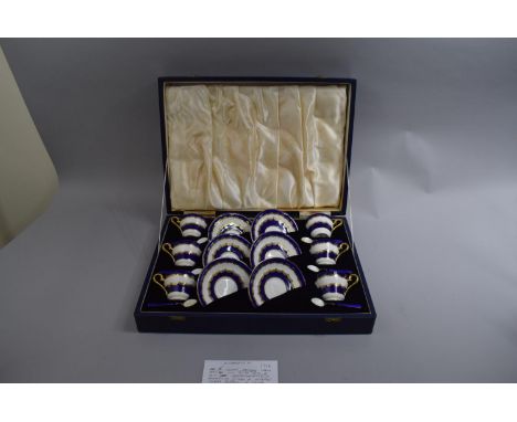 A Cased Aynsley Coffee Set comprising Six Cups and Saucers with Blue and Gilt Decoration with Matching Silver and Enamel Coff
