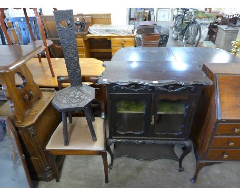 A carved oak spinning stool, Regency style chair and an Edward VII ebonised cabinet