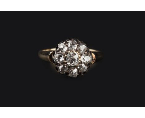 A DIAMOND CLUSTER RING, the circular cluster of cushion-shaped old-cut diamonds in claw setting, to a tapered mount stamped '