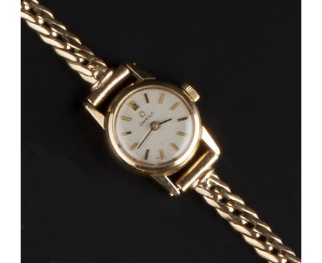 A LADY'S 9CT GOLD WRISTWATCH BY OMEGA, the circular signed silvered dial with baton markers, to a jewelled manual movement an