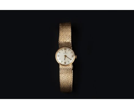 A LADY'S 9CT GOLD BRACELET WATCH BY OMEGA, the circular signed silvered dial with Arabic numerals and baton markers, to a sig