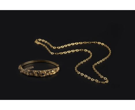 A SAPPHIRE SET BANGLE AND A CHAIN, the bangle of hinged oval form, pierced and engraved with flowerheads and foliage, highlig