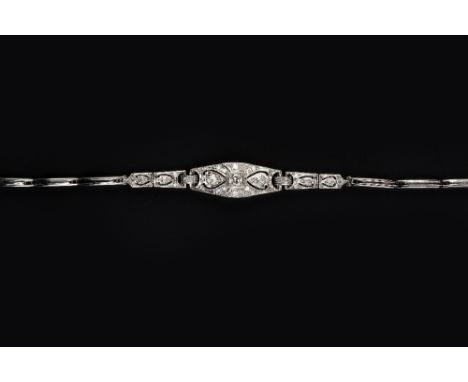 A DIAMOND SET PANEL BRACELET, centred with articulated panels of pierced design, millegrain set with graduated brilliant and 
