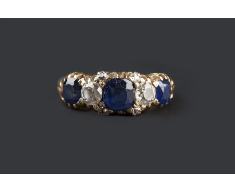 A SAPPHIRE AND DIAMOND HALF HOOP RING, set with a trio of cushion-shaped sapphires, spaced by two old-cut diamonds and smalle