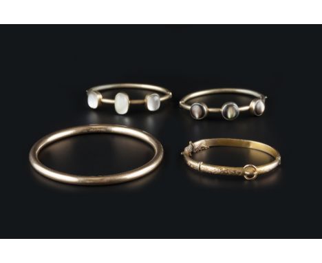 FOUR BANGLES, the first a slave bangle, with interior presentation inscription dated 1918, stamped '9 .375', together with tw