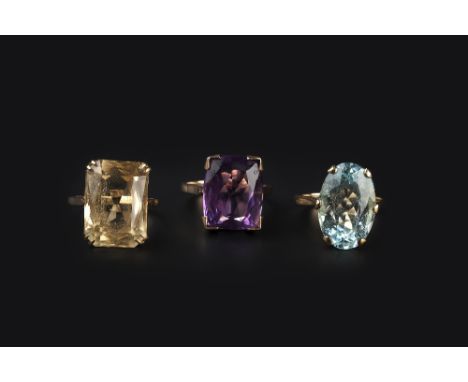 THREE GEM SET SINGLE STONE RINGS, the first claw set with an oval mixed-cut aquamarine, the second claw set with an oval mixe