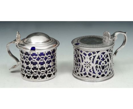 A VICTORIAN SILVER MUSTARD POT with pierced scroll decoration, matching engraved hinged lid and blue glass liner, 6.5cm high,