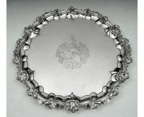A WILLIAM IV SILVER SALVER with a cast shell and scroll border, engraved central cartouche and standing on three cast scroll 