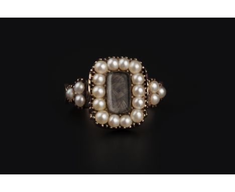 AN EARLY 19TH CENTURY ENAMEL AND HALF PEARL MEMORIAL RING, the rotating cushion-shaped panel with a plaited hairwork and half