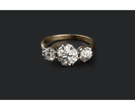 A DIAMOND THREE STONE RING, the graduated old brilliant-cut diamonds in claw setting, two colour precious metal mounted, numb
