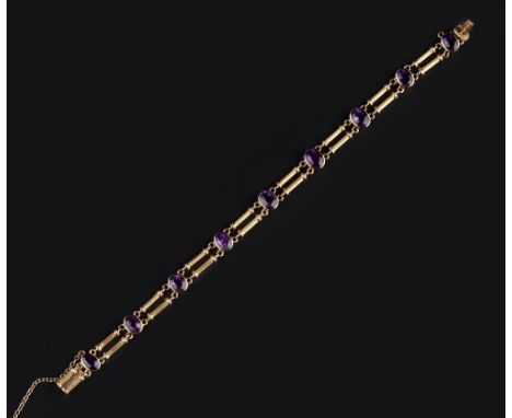 AN AMETHYST SET BRACELET, comprising a line of oval mixed-cut amethysts in collet settings, spaced by pairs of reeded baton l