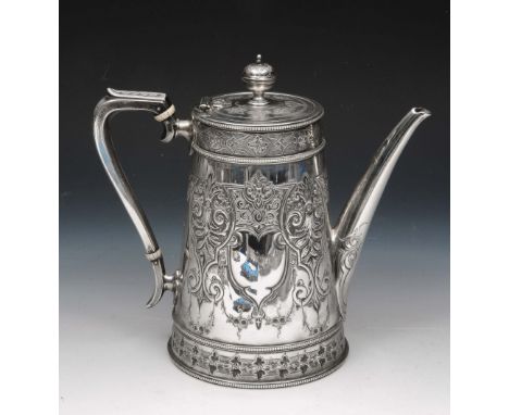 A VICTORIAN SILVER COFFEE POT with a tapering body and with chased panels decorated with scrolls and flower heads, hinged lid