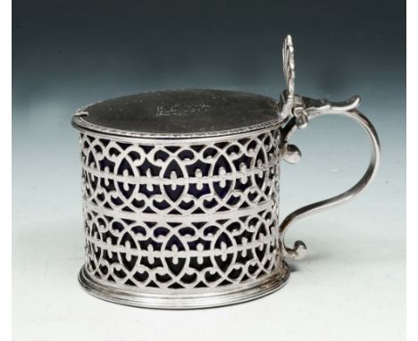 A GEORGE III SILVER MUSTARD POT with pierced scrolling decoration, hinged lid and blue glass liner, 7.2cm high, London 1773 b