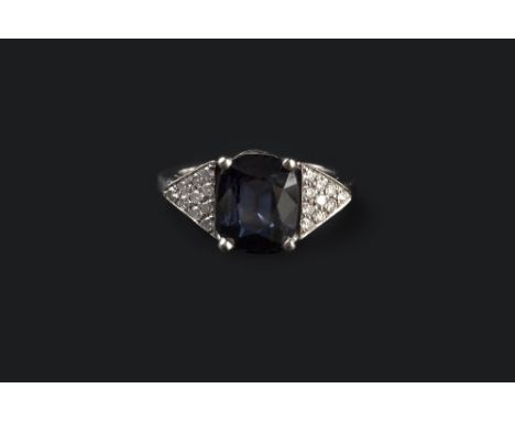 A SAPPHIRE AND DIAMOND DRESS RING, the cushion-shaped mixed-cut sapphire claw set between triangular shoulders, pavé set with