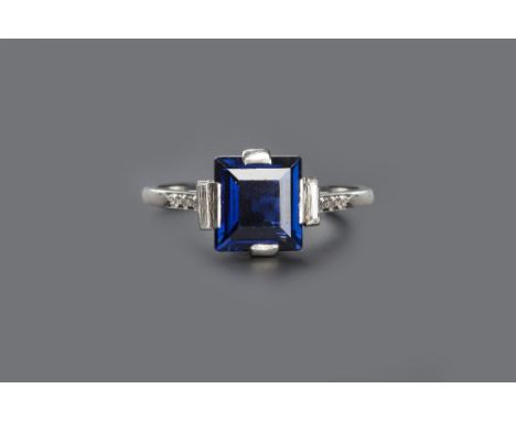 AN ART DECO SAPPHIRE AND DIAMOND RING, the rectangular step-cut sapphire claw set between baguette-cut diamonds, highlighted 