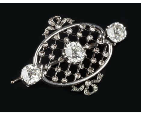 A DIAMOND PANEL BROOCH, centred with a trio of old-cut diamonds, to an oval lattice work panel highlighted with individual ro