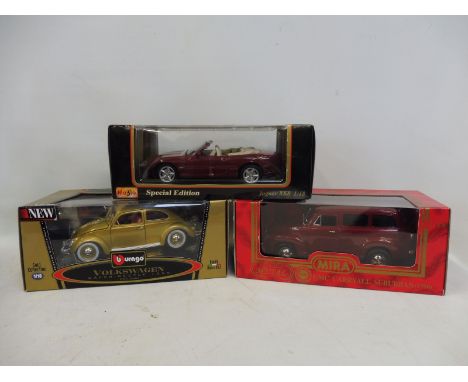 A boxed Burago 1/18 scale Volkswagen Beetle, a boxed Maisto Jaguar XK8 and one other. 