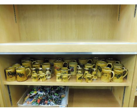 A shelf full of mugs decorated with images of motorcars.