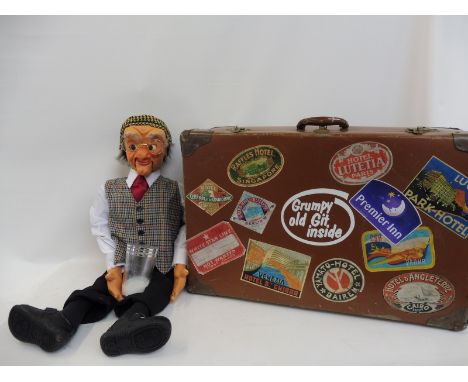 A 'Grumpy Old Git' with suitcase; Kalini made; moving eyes, mouth, moving arm stick with eyeglasses and a trick milk glass. 