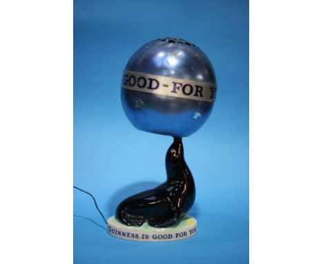 A 'Guinness is Good for You' seal table lamp with blue metallic spherical shade, printed marks to base.