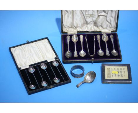 A cased set of spoons, coffee spoons, silver napkin ring, a caddy spoon and a silver mounted calendar.