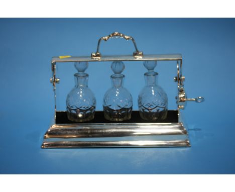 A small plated three bottle Tantalus.