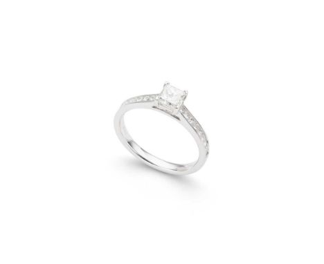 A diamond single-stone ring claw-set with a princess-cut diamond, each shoulder channel-set with nine princess-cut diamonds, 