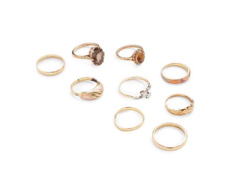 A collection of gem-set rings including a diamond two-stone twist ring, unmarked; a 9ct gold smokey quartz ring and a 9ct gol