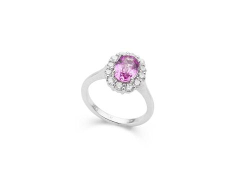 A pink sapphire and diamond cluster ring claw-set with an oval-cut pink sapphire in a border of round brilliant-cut diamonds,