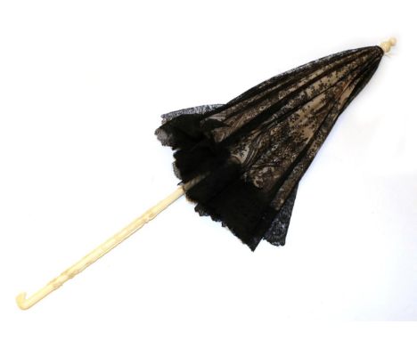 A Mid-19th Century Folding Parasol, the very fine black lace cover of fine Chantilly of elaborate design, lined in the origin