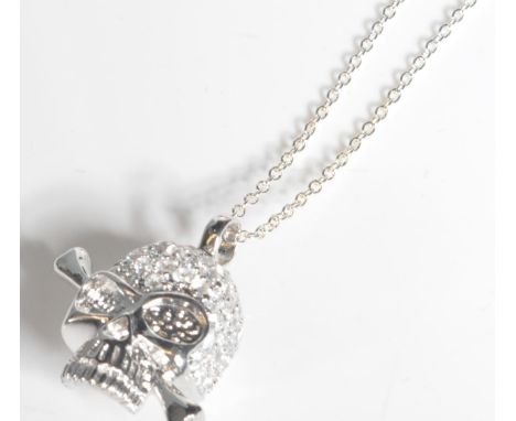 A stamped 925 silver necklace with a silver and CZ pendant in the form of a skull a d cross bones attached to a tracer chain 