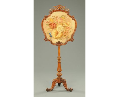 A Victorian walnut framed pole screen, with Berlin tapestry and raised on cabriole legs.  