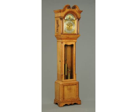 An Edwardian oak longcase clock, with swans neck pediment above the arched glazed door enclosing the silvered brass dial with