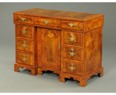 A 19th century walnut veneered Queen Anne style kneehole desk, with crossbanded moulded edge above a series of drawers and ce