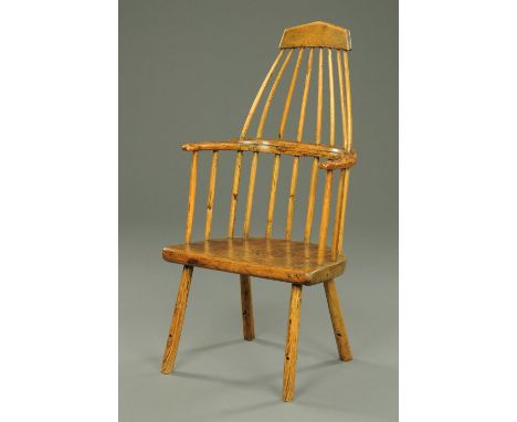 An antique Welsh primitive comb back elbow chair, with triangular top rail to tapering back with spindled supports, solid sea