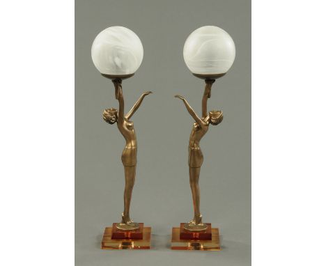 A pair of Art Deco style composition figural table lamps, each raised on a stepped square base, contemporary.   Height 56 cm.