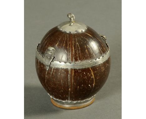 A George III coconut tea caddy, with silver coloured metal mounts.  Diameter 10 cm (see illustration).   CONDITION REPORT:  G