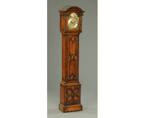 A 1920's oak cased grandmother clock, with three-train spring driven movement, complete with key and pendulum.  Height 167 cm