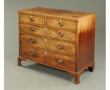 A George III mahogany chest of drawers, with two short and three long graduated drawers with brass drop handles with oval bac