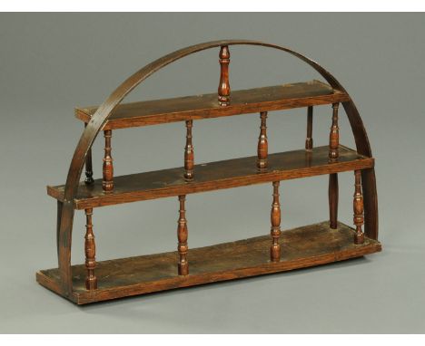 A George III oak three tier open wall shelf, with arched top and spindled supports.  Width 87 cm (see illustration).   CONDIT