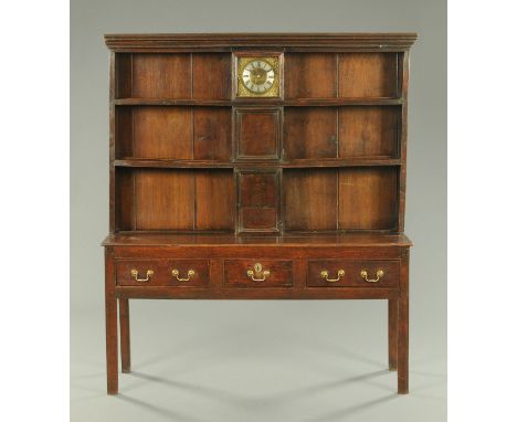 A George III oak dresser with clock, the brass faced thirty hour movement signed "J. Norris, Abingdon", the dresser with a se