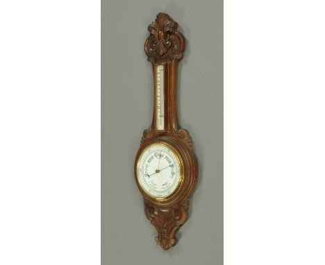 An Edwardian oak cased banjo aneroid barometer.  Height 91 cm.
