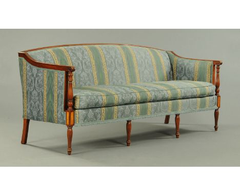 A Regency style mahogany framed settee, with upholstered back, sides and squab cushion in green and beige foliate patterned m