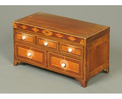 A George III mahogany miniature chest of drawers, with hinged top opening to a mirror and fitted with two frieze drawers with