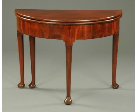 A George III mahogany demi-lune turnover top card table, raised on turned legs terminating in pad feet.  Width 96 cm (see ill